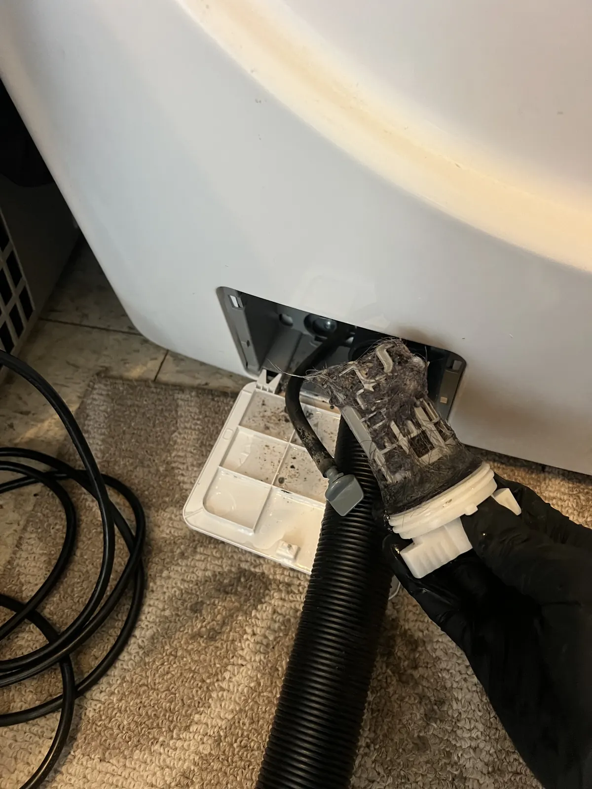 Clogged washer drain pump filter cleared during repair