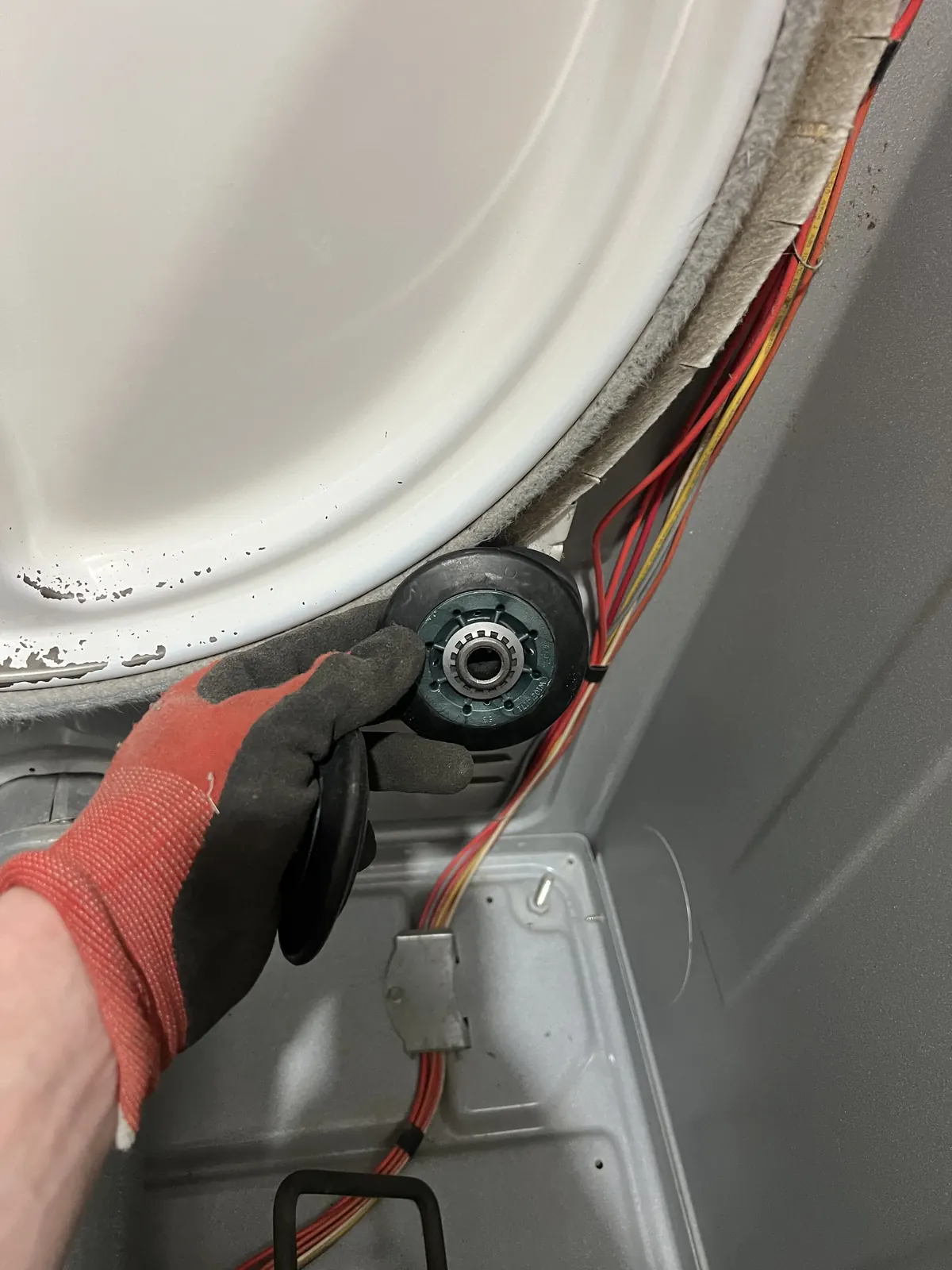 Dryer drum roller replacement in progress
